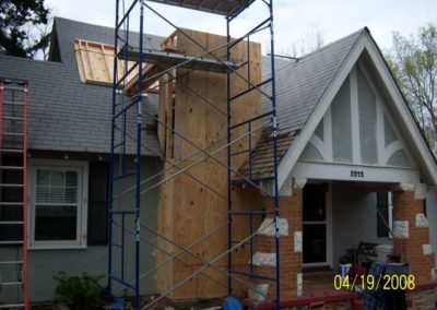 Chimney Wall Rebuild in progress with scaffolding and chimney framed out with wood