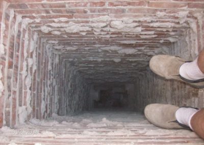 Technician's feet hanging down from top of chimney flue