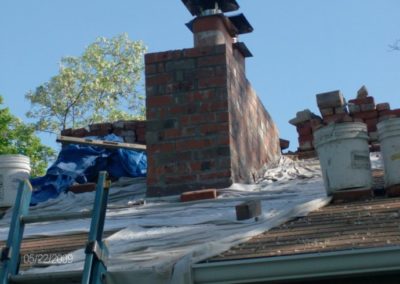 Chimney Stack Rebuild in progress with materials and ladder set up around roof