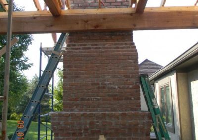 Patio deck awning being built while outdoor chimney rebuild is in progress