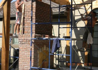 Technicians working on chimney rebuild with scaffolding in place