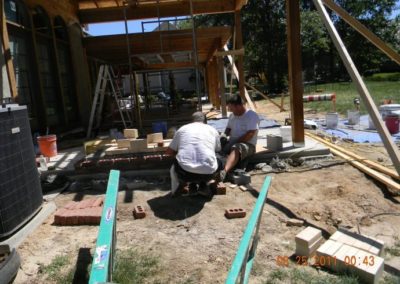 Outdoor Fireplace Foundations being built by two technicians with scaffolding and framing