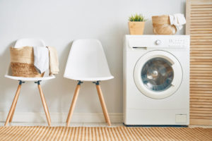 white chairs next to white clothing dryer on wooden floor