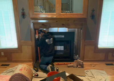 Technician installing fireplace insert